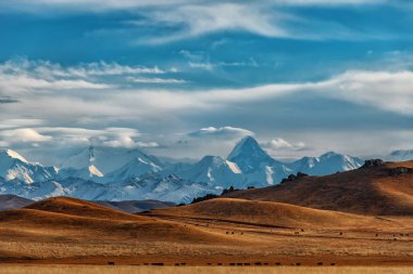 Kuzey Tien Shan sıradağları ve Khan Tengri zirvesi güneydoğu Kazakistan 'da bulutlu bir gökyüzünün altında.