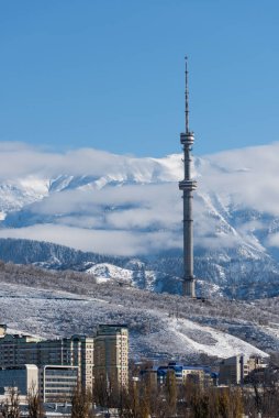 Almaty 'deki ünlü TV kulesi (Kazakistan), deniz seviyesinden 1400 metre yükseklikte, karlı dağların arka planına karşı yer almaktadır.