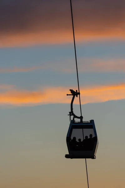 Seilbahnkabine Mit Menschensilhouetten Vor Dem Hintergrund Des Sonnenuntergangs — Stockfoto