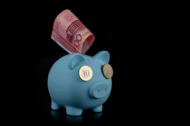 Siyah arka planda 10 Çin parası olan mavi domuz kumbarası.