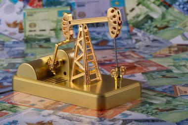 Oil pump against the background of Kazakh banknotes (tenge)