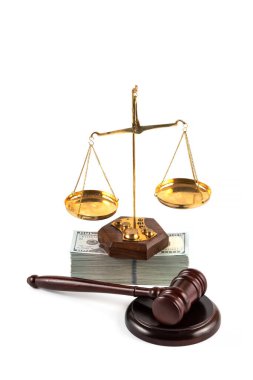 Judge's gavel, golden scales and a pack of American dollars on a white background