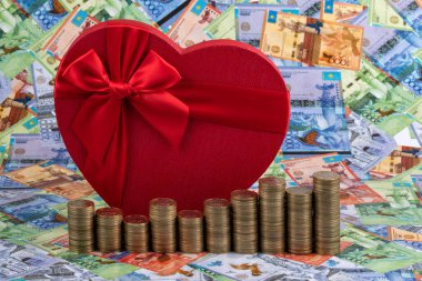 Gift box in the shape of a human heart and Kazakhstani currency - tenge