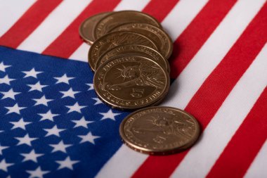 Coins in denominations of 1 American dollar  against the background of the state flag of the United States