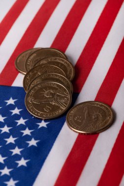 Coins in denominations of 1 American dollar  against the background of the state flag of the United States