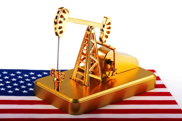 Gold oil pump against the background of the Stars and Stripes American flag
