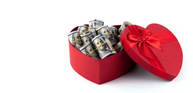 Beyaz arka planda 100 Amerikan doları banknotlarıyla dolu insan kalbi şeklinde bir hediye kutusu..