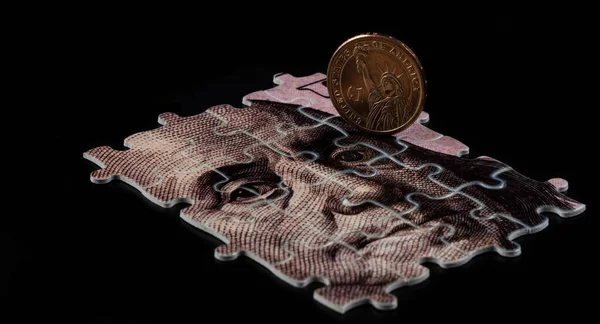 一个拼图的碎片描绘了本杰明 弗兰金的肖像 有一张100美元的钞票和一枚1美元的黑色背景硬币 — 图库照片