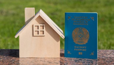 Minyatür ahşap ev ve Kazakistan Cumhuriyeti pasaportu.
