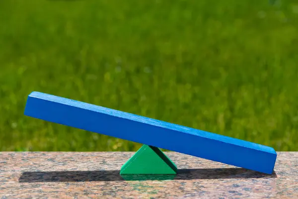 Równoważenie Niebieskiej Deski Zielonym Tle Trawy — Zdjęcie stockowe