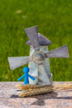 Sembolik ahşap yel değirmeni bir bahar sabahı yeşil çimlerin arka planında