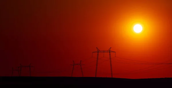Enorma Pyloner Högspänningsledning Och Solnedgången — Stockfoto