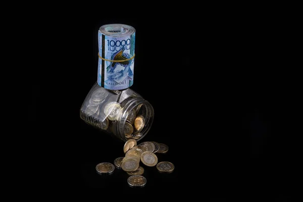 カザフスタンの10万枚の紙幣とガラス瓶を100枚と200枚の硬貨で巻き上げた — ストック写真