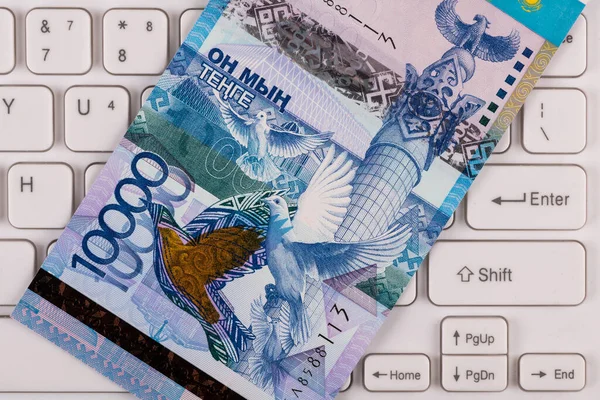 在计算机键盘上面值为10 000哈萨克斯坦坚戈的钞票 — 图库照片