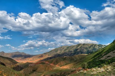 Kırmızı kayalar ve bulutlu gökyüzü ile manzaralı dağ manzarası