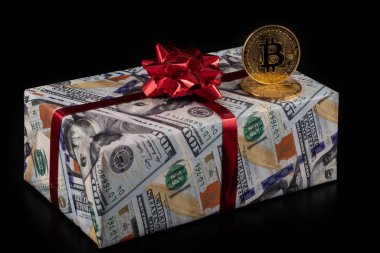 Şifreli para birimi Bitcoin 'in sembolü ve 100 Amerikan doları değerinde banknotların görüntüsü olan bir hediye kutusu.