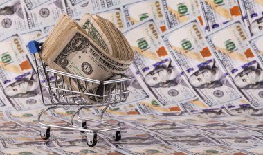 Bir süpermarket alışveriş arabasında 100 dolarlık banknotlarla dolu bir yığın.