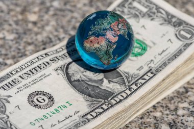 Cam minyatür küre ve 1 dolarlık banknotlar.