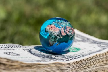 Cam minyatür küre ve 1 dolarlık banknotlar.