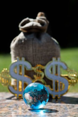 Sembolik cam küre ve Amerikan dolarının parlayan sembolleri.