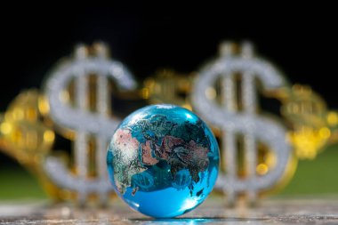 Sembolik cam küre ve Amerikan dolarının parlayan sembolleri.