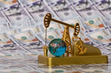 Altın yağ pompası ve cam küre 100 Amerikan dolarının arka planına karşı