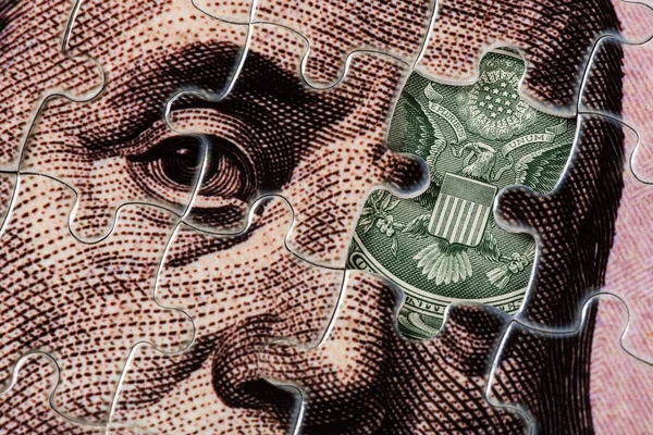 stock image A fragment of a 100 US dollar bill assembled from puzzles and a fragment of a 1 dollar bill with a picture of a bald eagle