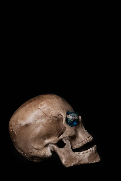 眼窩にガラスの地球を持つ人間の頭蓋骨 — ストック写真