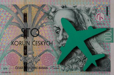 Bir yolcu uçağının minyatür modeli ve 100 Çek kronu.