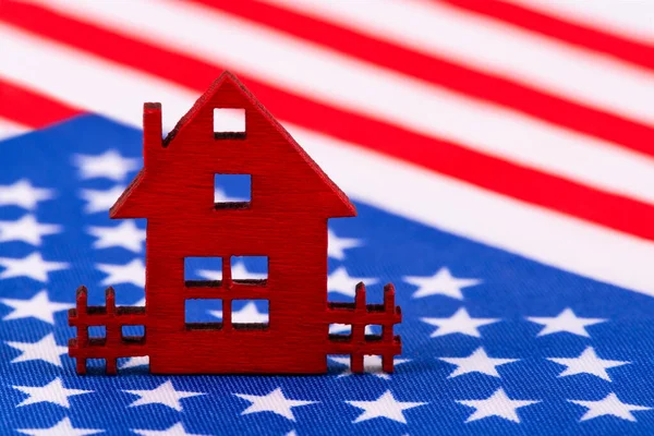 Red symbolic wooden house on the American flag