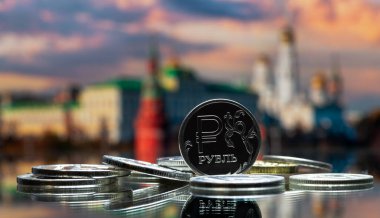 Rus rublesinin sembolü olan sikke Moskova Kremlin 'inin arka planına karşı.