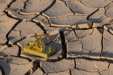 Çölde çatlamış kil üzerinde petrol pompasının altın modeli.