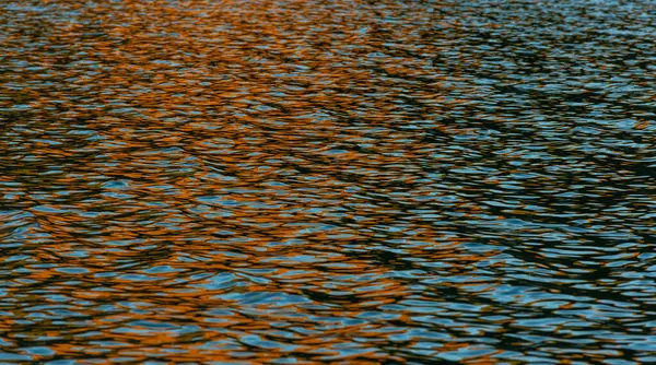 Background image of the lake surface with reflections of the rising sun