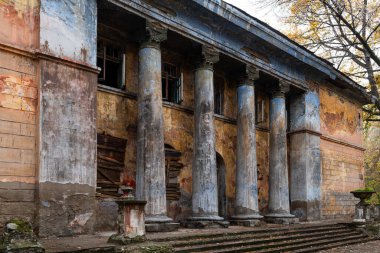 Bulutlu bir günde kolonları olan terk edilmiş eski bir bina.