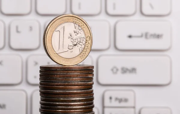 1 euro coin on computer keyboard background