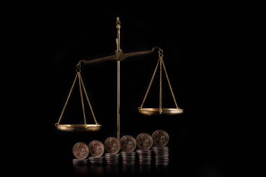 Adalet terazileri ve siyah arkaplanda 1 Amerikan doları sikkeleri
