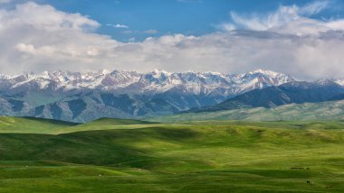 Trans-Ili Alatau 'daki (Kazakistan) karla kaplı tepe zeminine karşı pitoresk bir plato)