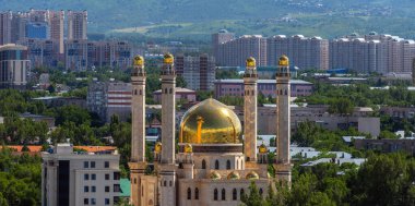 Kazak şehri Almatı 'nın kuş bakışı manzarası. Şehir bloklarının arka planına karşı pitoresk bir cami.