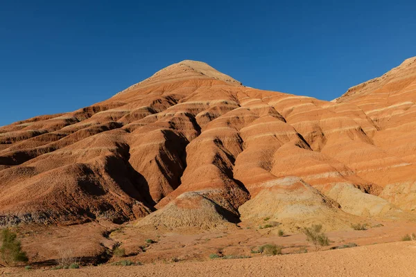 Kazakistan 'ın Altyn Emel doğa koruma alanındaki renkli kil dağları bir yaz akşamı