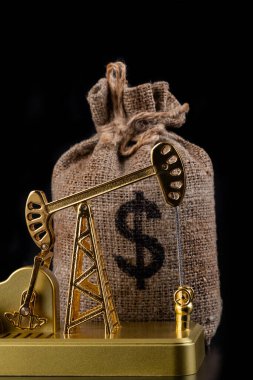 Altın minyatür yağ pompası ve Amerikan doları sembollü para çantası.