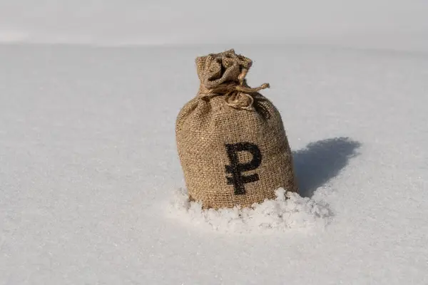 Conceptual story about the freezing of Russian assets with a money bag immersed in snow with a symbol of the Russian ruble