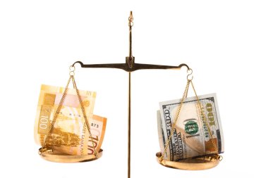 Altın pulunun bir tarafında 100 ruble banknot ve terazinin diğer tarafında 100 dolar.