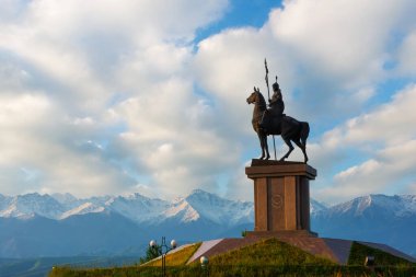 Almaty bölgesi, Kaskelen, Kazakistan. 06.07.2019. 18. yüzyıl Nauryzbay Batyr 'ın ünlü Kazak komutanının anıtı Trans-Ili Alatau dağlarının arka planına karşı.