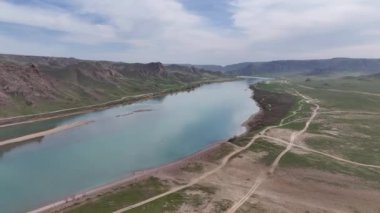 Kazakistan 'ın ana nehirlerinden biri olan Ili' nin, ülkenin güneydoğusundan Balkhash Gölü 'ne akan bir kuadkopterinin görüntüsü.