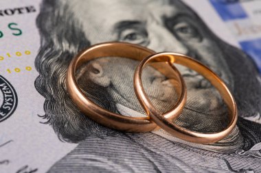 100 dolarlık banknotun arka planında altın alyanslar var.