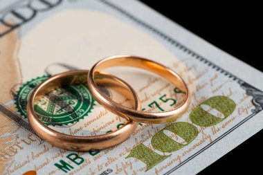 100 dolarlık banknotun arka planında altın alyanslar var.