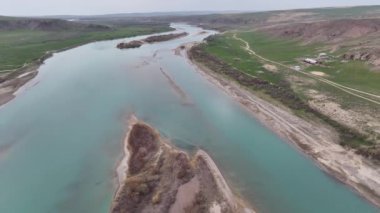 Kazakistan 'ın ana nehirlerinden biri olan Ili' nin, ülkenin güneydoğusundan Balkhash Gölü 'ne akan bir kuadkopterinin görüntüsü.