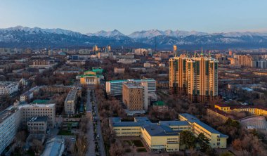 Kazakistan 'ın en büyük şehri olan Almaty' nin merkez kısmının bir kuadkopterinden Trans-Ili Alatau dağ sırasının arka planına doğru görüntülenir.