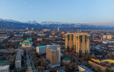 Kazakistan 'ın en büyük şehri olan Almaty' nin merkez kısmının bir kuadkopterinden Trans-Ili Alatau dağ sırasının arka planına doğru görüntülenir.