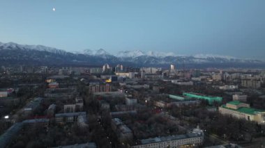 Kazakistan 'ın en büyük şehri olan Almaty' nin merkez kısmının bir kuadkopterinden Trans-Ili Alatau dağ sırasının arka planına doğru görüntülenir.